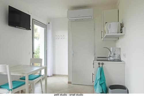 une cuisine avec une table et des chaises et une fenêtre dans l'établissement 456 Chemin de la Pinède, à Menton