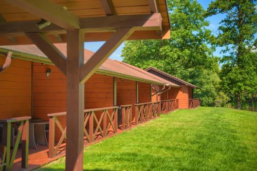 a wooden building with a green lawn in front of it at Hotel Dworek Wapionka in Górzno