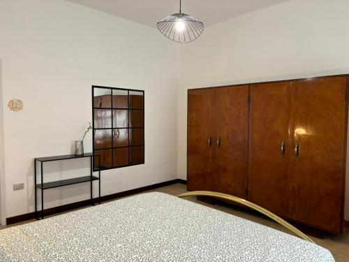 a bedroom with a bed and a wooden cabinet at Eleganza retrò con vista sulla Basilica in Loreto