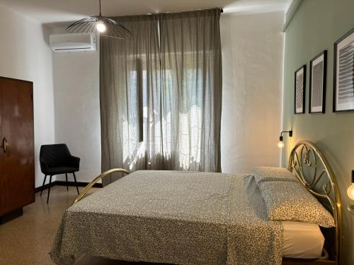 a bedroom with a bed and a window with a chair at Eleganza retrò con vista sulla Basilica in Loreto