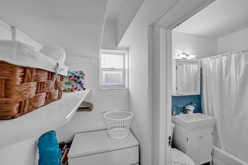 Un baño blanco con inodoro y lavabo. en Waves On Desoto Rental Unit With Pool, en Hollywood