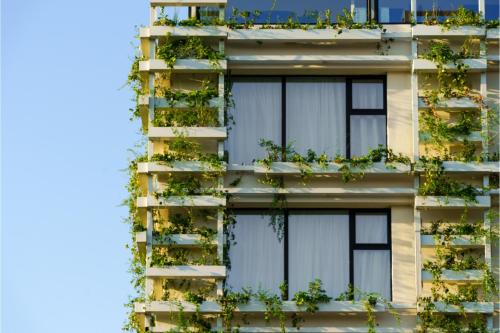 an apartment building with plants on the facade at The Athenaeum Luxury Hotel in Athens