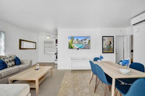 a living room with a table and blue chairs at Waves On Desoto Rental Unit With Pool in Hollywood