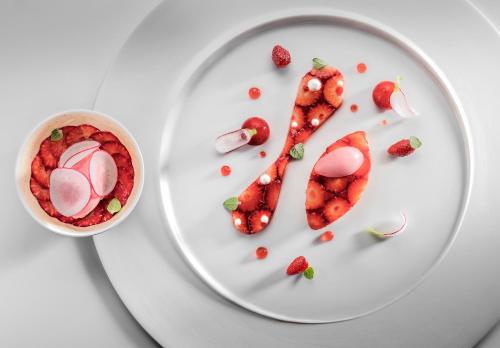 a plate of food with a letter k and strawberries at La Réserve de Beaulieu in Beaulieu-sur-Mer