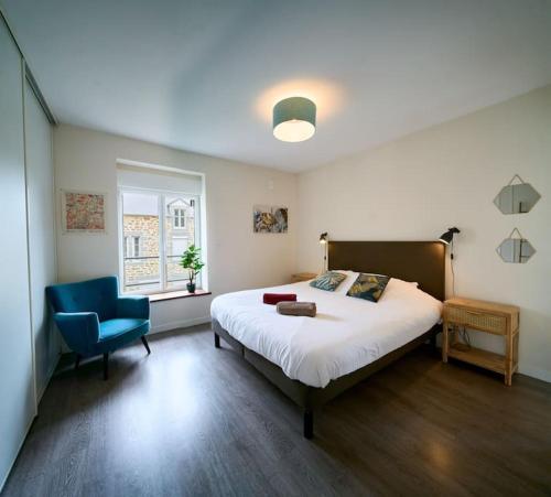 une chambre avec un lit et une chaise bleue dans l'établissement Corps de Ferme Idyllique en Bord de Rance, à Pleudihen-sur-Rance