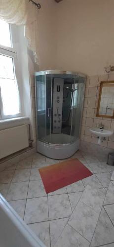 a bathroom with a glass appliance on a tiled floor at Pałac Stanica in Przeworno