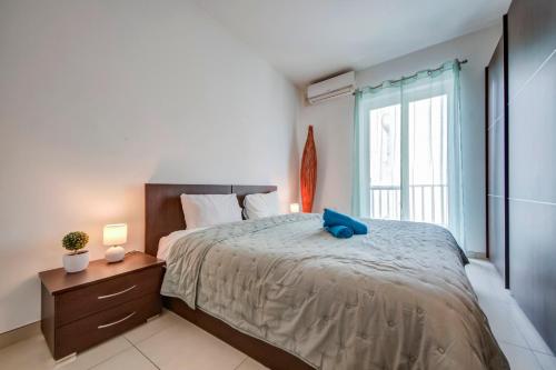 Un dormitorio con una cama grande con una almohada azul. en Modern 2BR Apt with Balconies in St Julians, Paceville - APT 5 by Vaganza, en San Julián