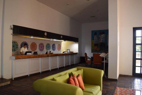 un vestíbulo con un sofá verde y un bar en Hacienda del Mar Resort Condominio 205, en Cancún