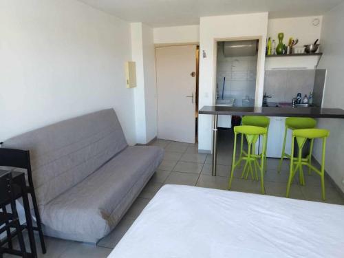 un salon avec un canapé et des tabourets verts dans l'établissement FREJUS Studio avec place de parking, à Fréjus