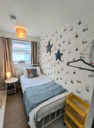 a bedroom with a bed with stars on the wall at Seabreeze Pet friendly 3 bedroom house by the sea in Gorleston-on-Sea