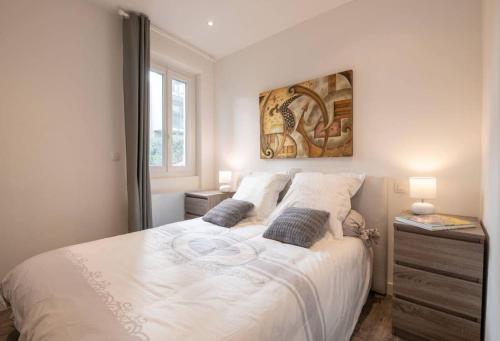 une chambre avec un grand lit blanc avec deux oreillers dans l'établissement Suite Sainson AC 4 min à pied de la Plage, à Nice