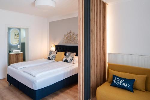 a hotel room with a bed and a chair at Pension Auszeit Velden in Velden am Wörthersee