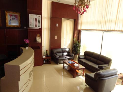 a living room with two couches and a television at Palette Top Stars Hotel in Abu Dhabi