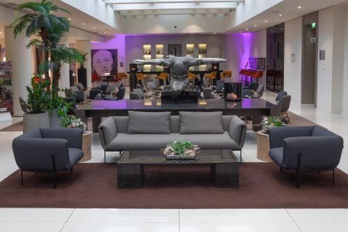 a lobby with couches and a table in a building at H10 Berlin Ku'Damm in Berlin