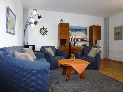 un soggiorno con divani blu e un tavolo di Atlantischer Hof 29, Königstraße a Wyk auf Föhr