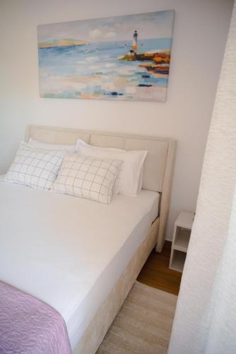 a bedroom with a bed with a painting on the wall at Apartmani Natalija 4 Stars in Mrljane