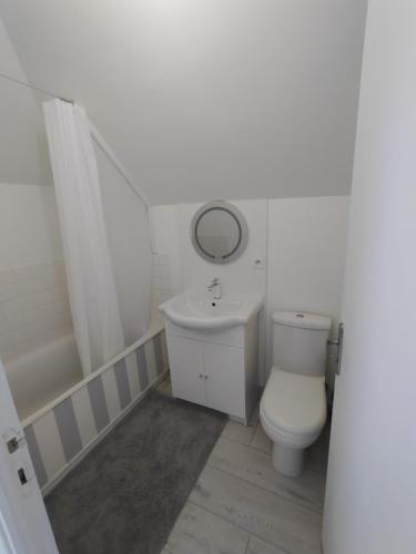 a white bathroom with a sink and a toilet at résidence le parc in Condé-sur-Noireau