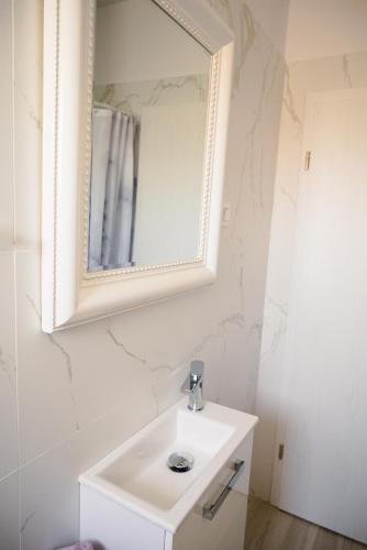 a bathroom with a white sink and a mirror at Apartmani Natalija 4 Stars in Mrljane