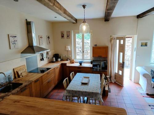 une cuisine avec une table et une salle à manger dans l'établissement Ceps Cottage sleeps 6 with free wifi near the river, à Roquebrun