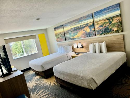 a hotel room with two beds and a flat screen tv at Days Inn by Wyndham Williams in Williams