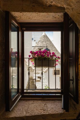 a window with a pot of flowers on a balcony at Il Trullo Moore Alberobello in Alberobello