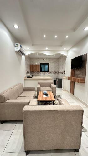 a living room with two couches and a table at Buyot Malath Serviced Apartment - شقق بيوت ملاذ للشقق المخدومة in Jeddah