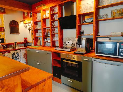 une cuisine avec des appareils en acier inoxydable et un micro-ondes dans l'établissement Gite atypique, à Plounéour-Trez