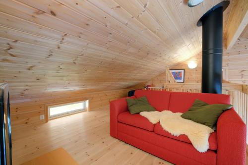 a red couch in a room with wooden walls at Voss Resort self-service apartments in Skulestadmo