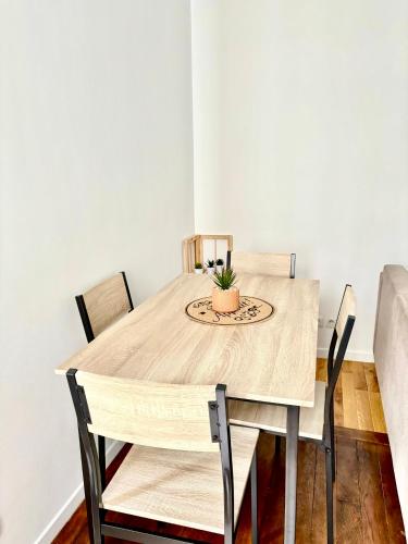 d'une table à manger avec des chaises et une plante. dans l'établissement À Deux pas du Metro Louise Michel, à Levallois-Perret