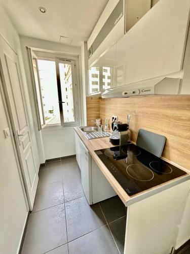 Il comprend une cuisine équipée d'un évier et d'une cuisinière. dans l'établissement À Deux pas du Metro Louise Michel, à Levallois-Perret