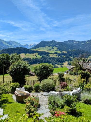 a garden with two boats in the grass with mountains in the background at Swiss Mountain-Valley View Lodge in Erlenbach im Simmental