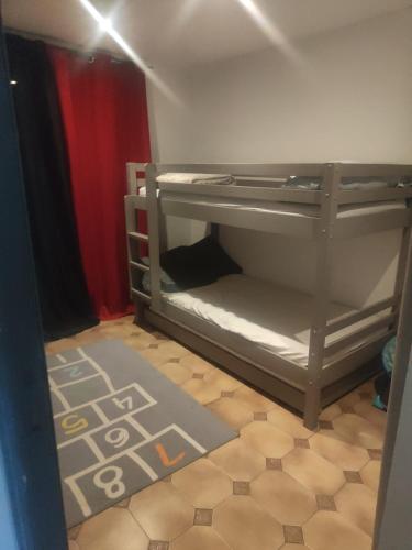 une chambre avec un lit superposé avec un plancher dans l'établissement Location maison avec piscine privée., à Agde