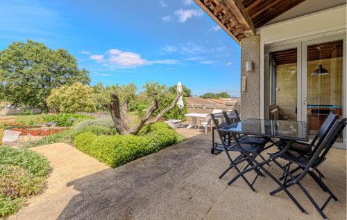 eine Terrasse mit einem Tisch und Stühlen auf einem Haus in der Unterkunft Cozy Home In Aubarne Santanastasie in Sainte Anastasie - Aubarne