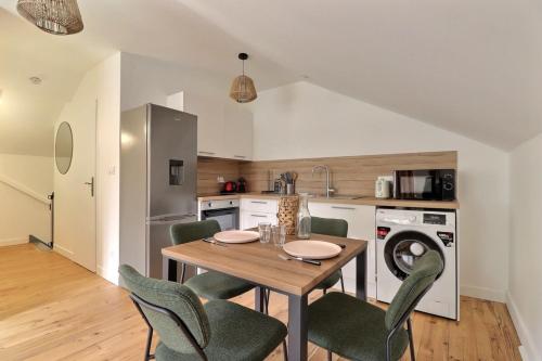 une cuisine avec une table et des chaises dans une cuisine dans l'établissement Le Zanzibar - Lovely Bright Apartment - Villeurbanne, à Villeurbanne