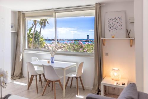 un salon avec une table et une grande fenêtre dans l'établissement Beau 2P bord de mer, Marina baie des anges, à Villeneuve-Loubet