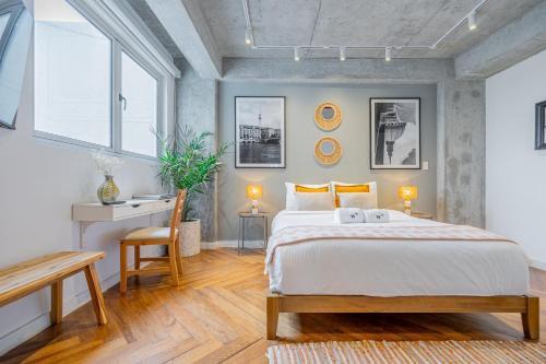 a bedroom with a bed and a desk and windows at Casa Contemporánea by Wynwood House in Panama City