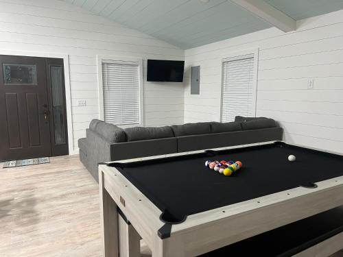 a living room with a pool table and a couch at Stay, play and relax in Ohiopyle, PA, Hot tub, Pool table, next to the GAP trail in Ohiopyle, PA in Ohiopyle