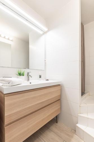 une salle de bain avec un lavabo et un miroir dans l'établissement Beau 2P bord de mer, Marina baie des anges, à Villeneuve-Loubet