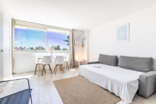 un salon blanc avec un canapé et une table dans l'établissement Beau 2P bord de mer, Marina baie des anges, à Villeneuve-Loubet