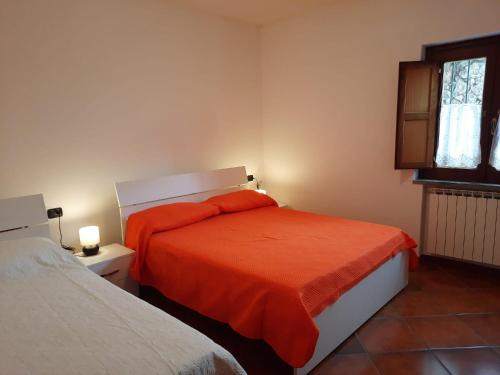ein Schlafzimmer mit einem Bett mit einer orangefarbenen Decke in der Unterkunft Villa del Poggio Marina di Camerota in Lentiscosa