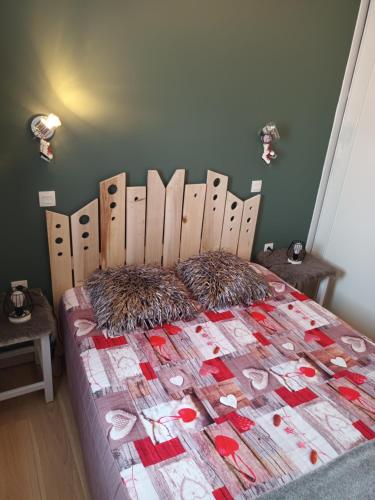 une chambre avec un lit avec une tête de lit en bois dans l'établissement Apt cosy, lumineux,idéalement placé, à Valmeinier