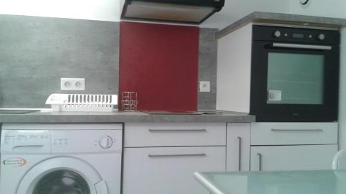 une cuisine avec un lave-linge et un micro-ondes dans l'établissement studio, à Antony