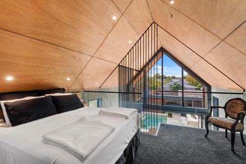 Un dormitorio con una cama y una ventana grande. en Divine on Derby - Christchurch Holiday Home, en Christchurch