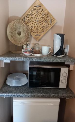 a kitchen counter with a microwave and a fan at Acacia Gastehuis in Kathu