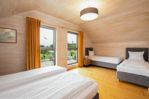 a bedroom with two beds and a window at Domki Asgard in Gąski