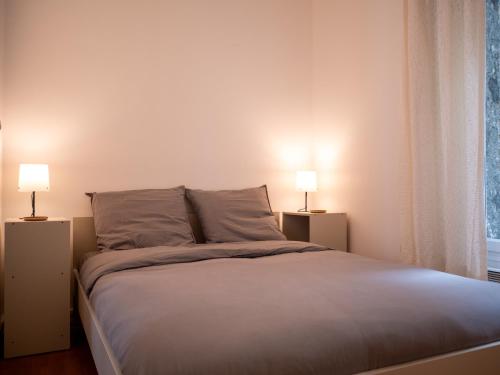 une chambre avec un grand lit avec deux lampes dans l'établissement Appartement à 5 mins Tour Effeil, à Paris