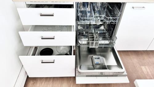 un lave-vaisselle vide avec sa porte ouverte dans une cuisine dans l'établissement Suite Dalmate - Check in h24 - Wifi, à Lyon