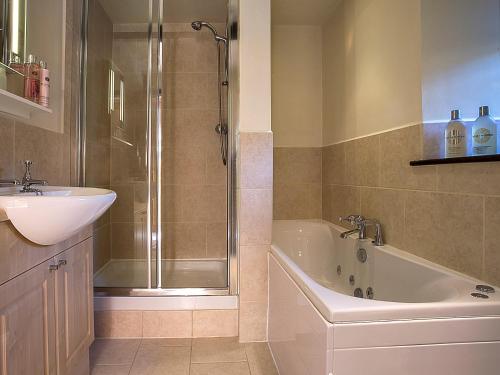 コニストンにある5 Bed in Coniston LCC28の洗面台、浴槽、シャワーを備えたバスルーム