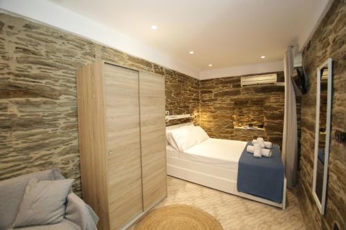 a bedroom with a bed and a stone wall at Chora's Stonehouse in Andros