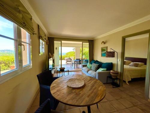 un salon avec une table et un canapé dans l'établissement Les Restanques 3019 grande terrasse vue mer, à Grimaud